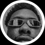 Godwin in black and white, close to the camera in wide sunglasses