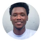 Godwin outdoors in a white t-shirt, smiling